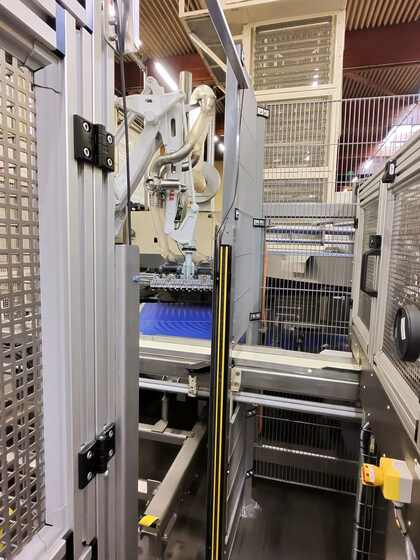 Vue d'ensemble de la cellule robotisee de demoulage avec convoyeur bleu, agroalimentaire